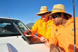 Two RoadTeks workers viewing laptop on vehicle bonnet